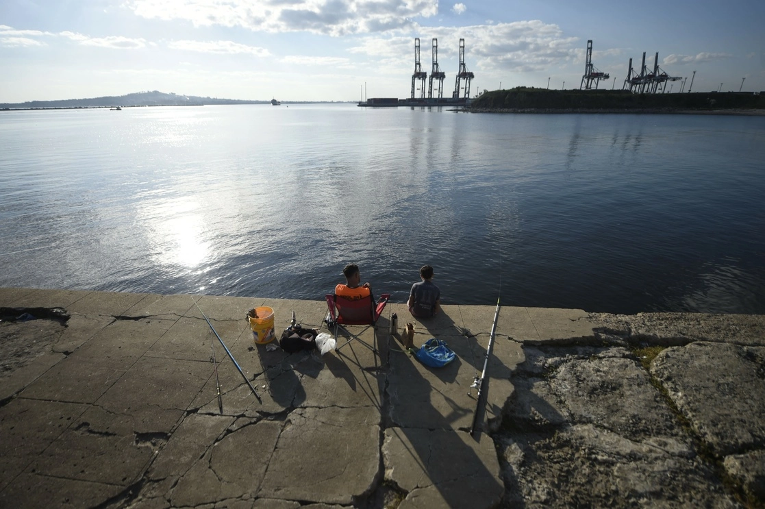 Un hombre y su hijo pescan en el Puerto de Montevideo. Foto Xinhua