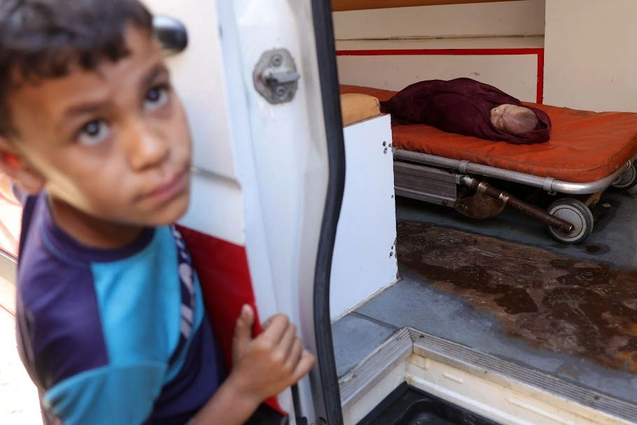 Un niño observa el retiro y traslado de un bebé muerto, tras un ataque israelí que impactó la casa de una familia palestina en Jabaliya. Foto 
