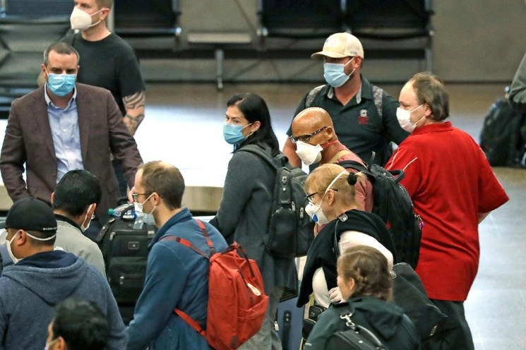 Viajeros usan cubrebocas mientras esperan su equipaje en el Aeropuerto Internacional de Seattle. Foto Ap
