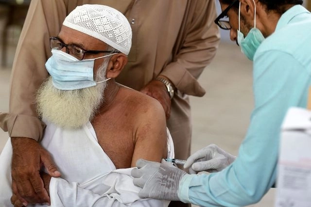 Un trabajador de la Salud aplica a un hombre la vacuna de AstraZeneca en Karachi, Pakistán. Foto Afp 