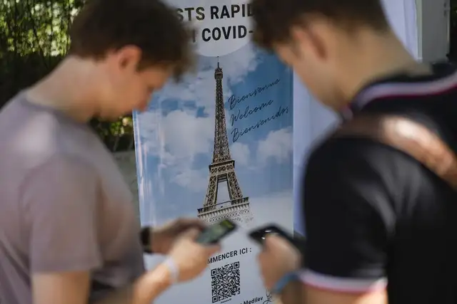 Visitantes se registran para una prueba de coronavirus en la Torre Eiffel, en París, el 21 de julio de 2021. Foto Ap