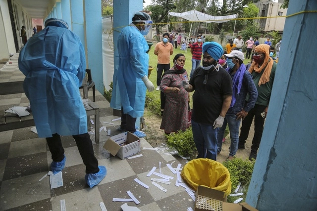 Personas esperan para presentar la prueba de Covid-19 en Jammu, India. Foto Ap 