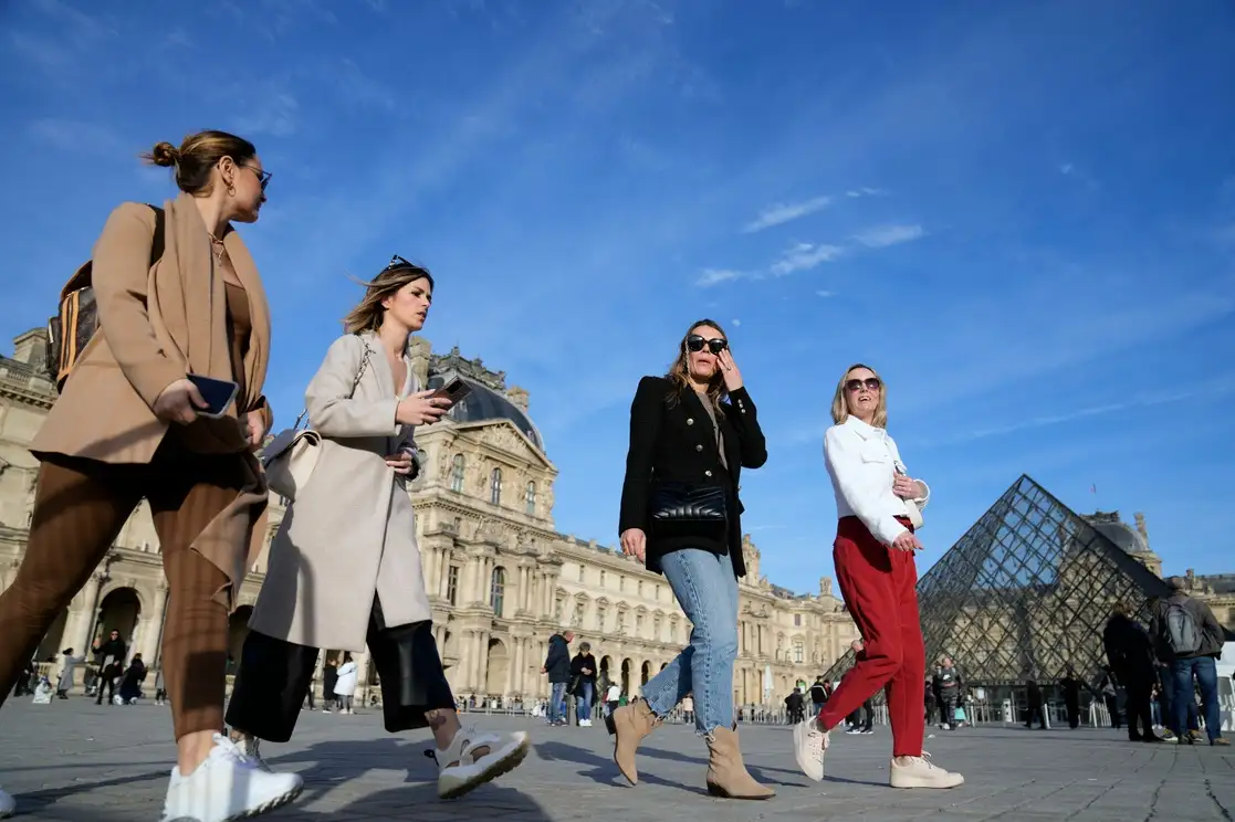 Turistas sin cubrebocas caminan junto al Museo del Louvre, en París, el pasado lunes 14 de marzo de 2022. Francia levantó la mayoría de las restricciones por el covid-19, al permitir que las personas se quiten los cubrebocas en casi todos los lugares y que los no vacunados vuelvan a entrar a restaurantes, estadios deportivos y otros lugares de ocio. Foto Ap