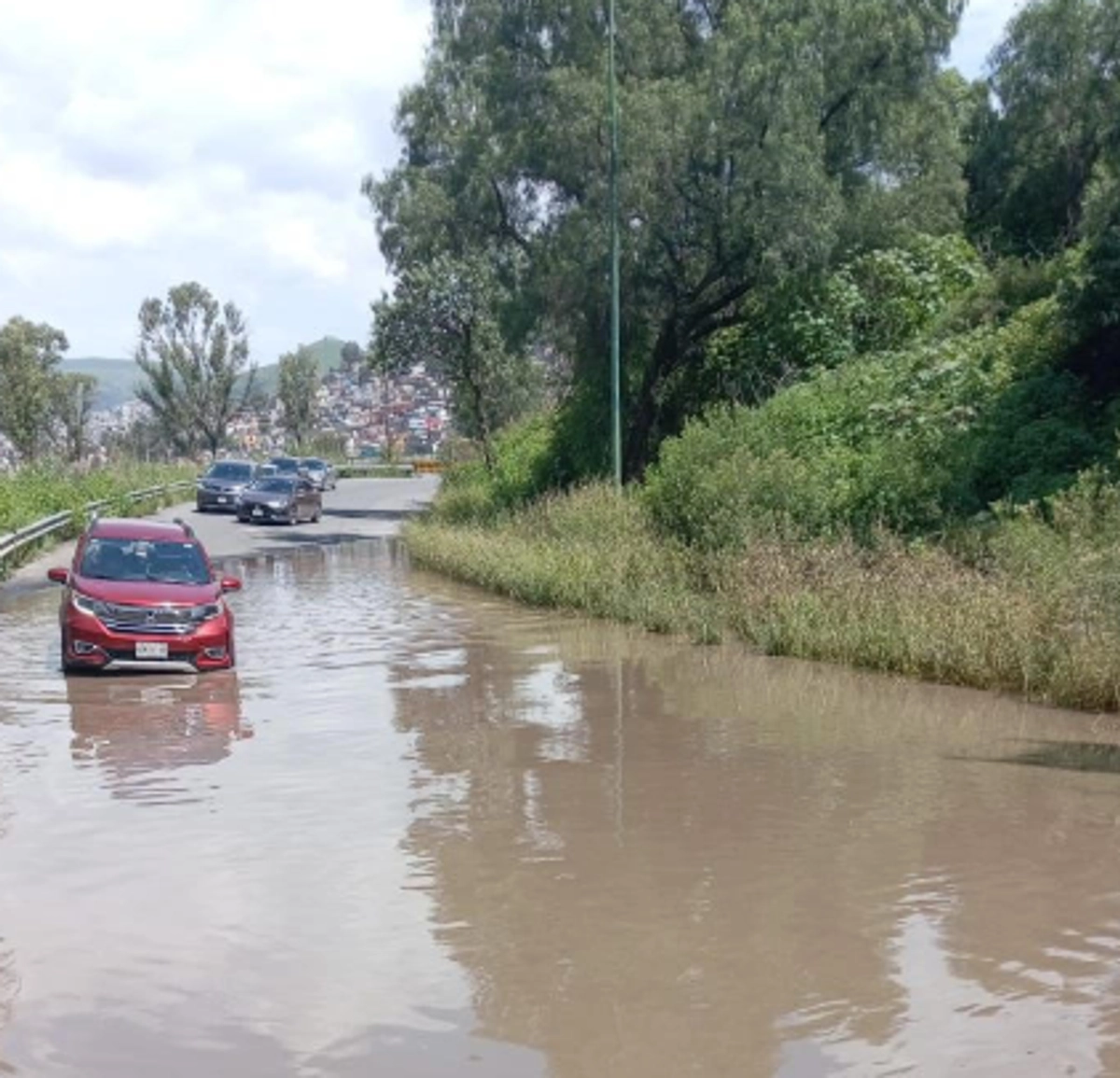 Indicaron que este año varios vehículos han quedado atrapados en el tramo vial debido a que los conductores, en su desesperación, tratan de sortear la inundación. Indicaron que, con la llegada de bodegas industriales, se deterioran las vialidades y aumentó el número de vehículos de carga que cruzan por su comunidad. Foto 