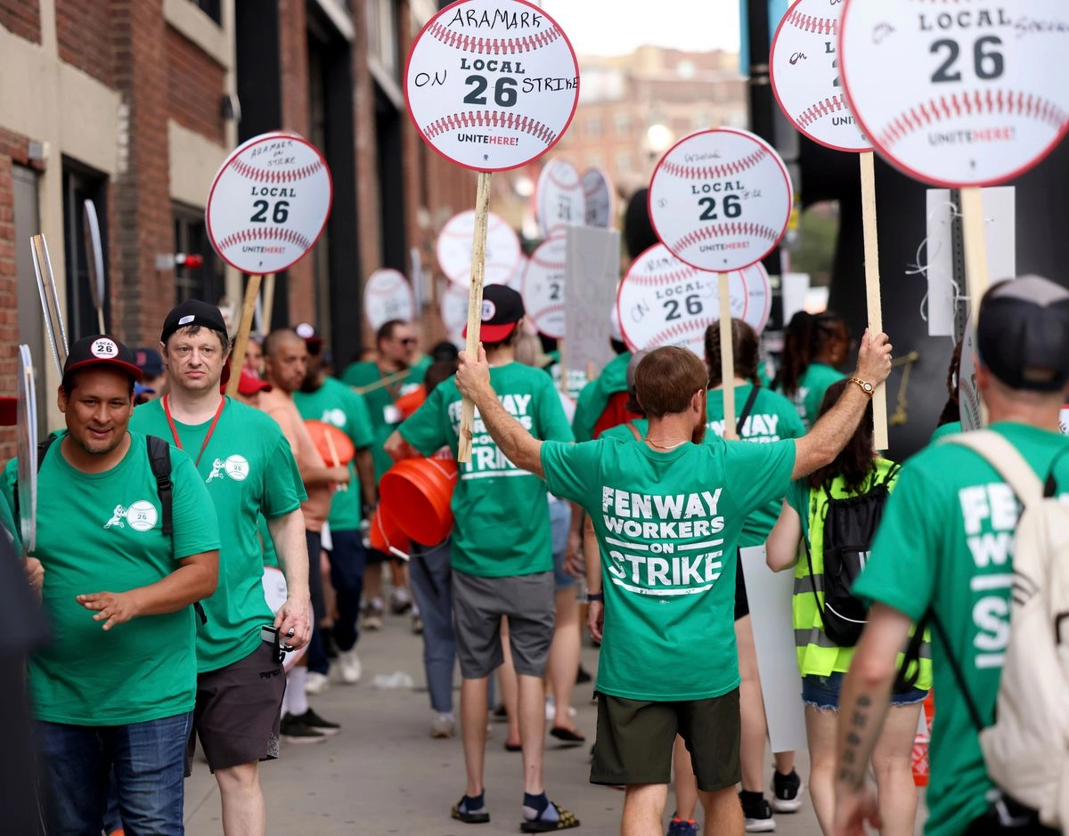 Trabajadores de concesiones de Fenway Park protestan frente al estadio el viernes 25 de julio de 2025 en Boston, antes de un partido de béisbol entre los Medias Rojas de Boston y los Dodgers de Los Ángeles. Foto