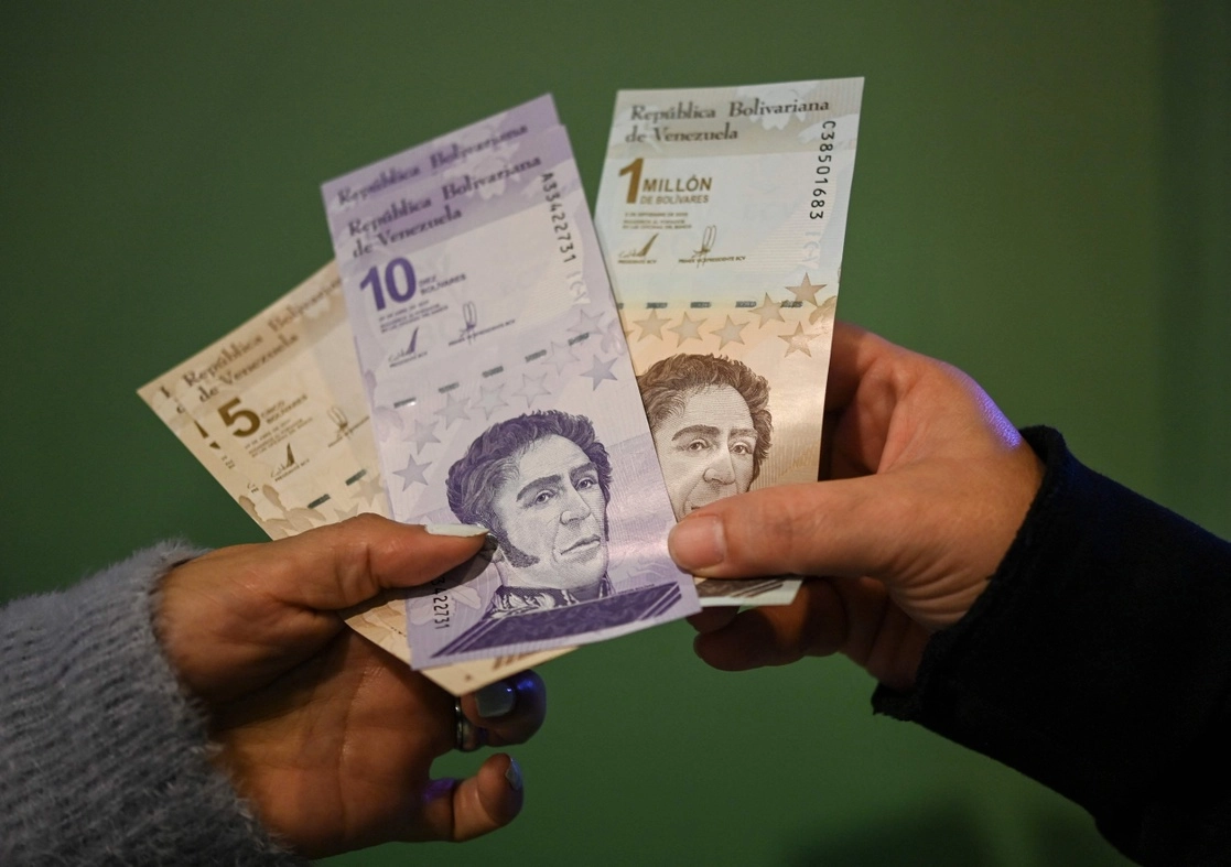 Una persona muestra los nuevos billetes de cinco y 10 bolívares en circulación por el Banco Central de Venezuela, el 1 de octubre de 2021. Foto Afp