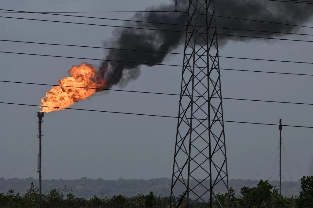 La llama de una chimenea de una planta de refinación de petróleo se ve a lo largo de la carretera entre El Furrial y Maturín en el estado de Monagas, Venezuela, el 7 de abril de 2023. Foto Afp
