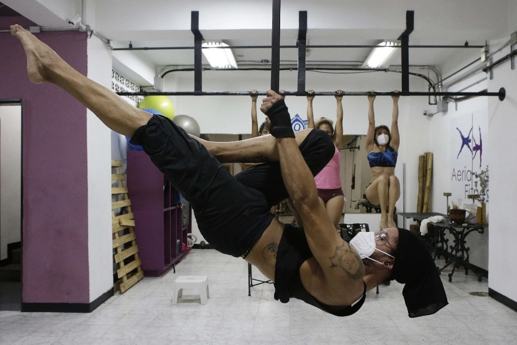 Personas portando cubrebocas mientras se ejercitan durante una clase de baile de barra en una academia, en Caracas, Venezuela. Foto Xinhua