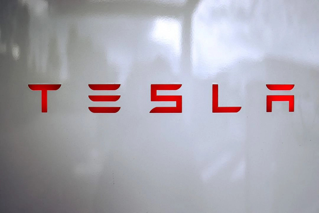 Logotipo de Tesla en una estación de carga (Tesla Supercharger) en Chasse-sur-Rhone, en el centro de Francia. La firma dio a conocer otra fuerte caída en las ventas de automóviles, lo que extiende un período difícil en medio de la intensificación de la competencia de vehículos eléctricos y la reacción violenta por las actividades políticas de Musk.