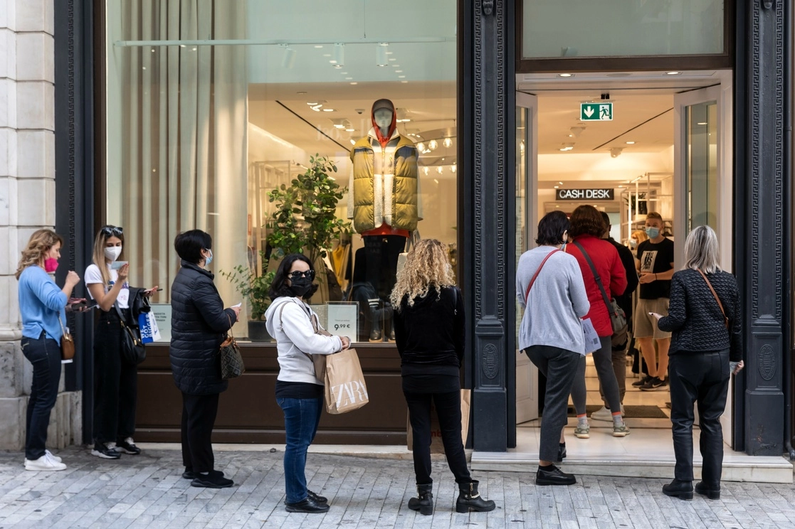 Un grupo de personas hacen fila para entrar a comprar ropa en una tienda de Atenas, Grecia. Foto Ap