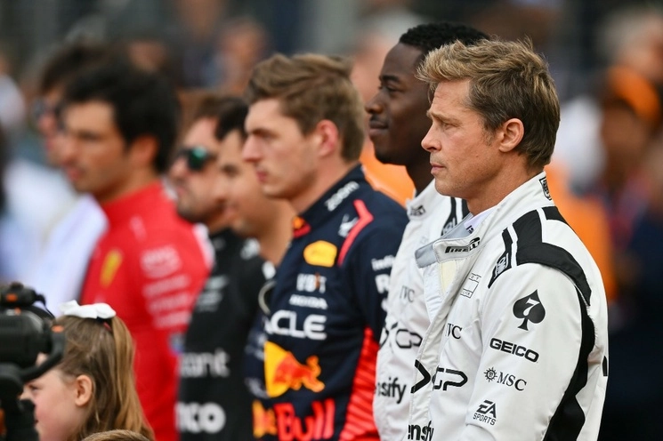 En primer plano los actores Brad Pitt y Damson Idris caracterizados de pilotos; al centro de la imagen el campeón Max Verstappen, enseguida Sergio Pérez. Foto tomada del sitio www.facebook.com/Formula1