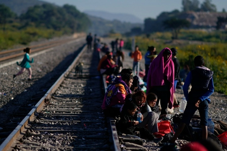 Migrantes esperan junto a las vías a que pase un tren que puedan abordar en su periplo hacia EU. Foto Ap