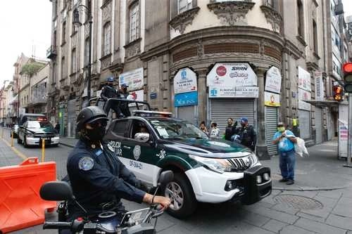 Policías capitalinos fueron desplegados en calles del Centro Histórico para impedir que el comercio ambulante se instale y el establecido cumpla con el cierre ante el desbordamiento de visitantes a la zona. Foto Roberto García Ortiz