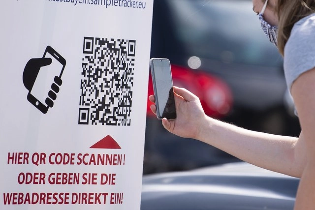 Una mujer escanea un código QR con su celular en un centro de pruebas de coronavirus en Kiefersfelden, Alemania. Foto Ap 