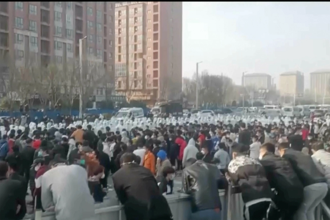 Manifestantes se enfrentan al personal de seguridad en la fábrica operada por Foxconn Technology Group, que administra la fábrica de iPhone de Apple más grande del mundo en Zhengzhou, China. Foto Ap