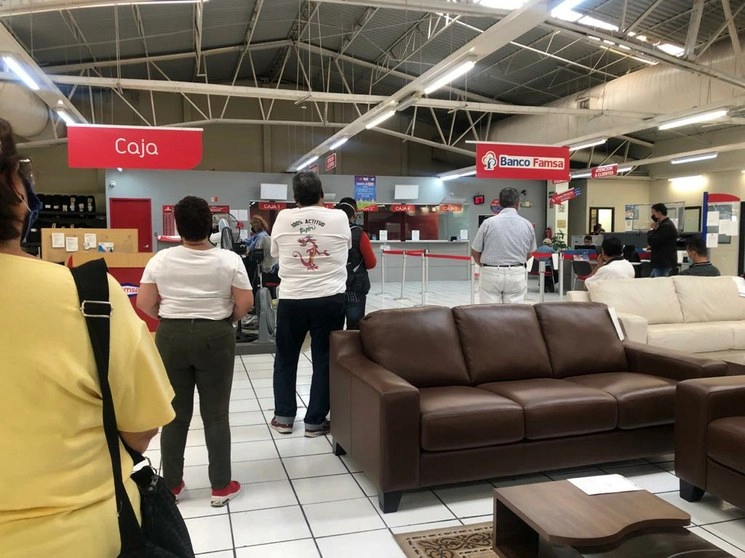 Usuarios de Banco Famsa realizan filas para poder retirar los ahorros de sus cuentas. Foto Yazmín Ortega Cortés