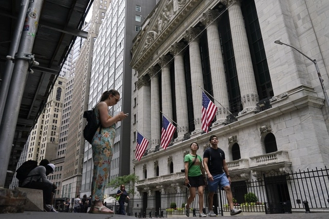 Personas caminan frente a la sede de la Bolsa de Valores de Nueva York. Foto Ap