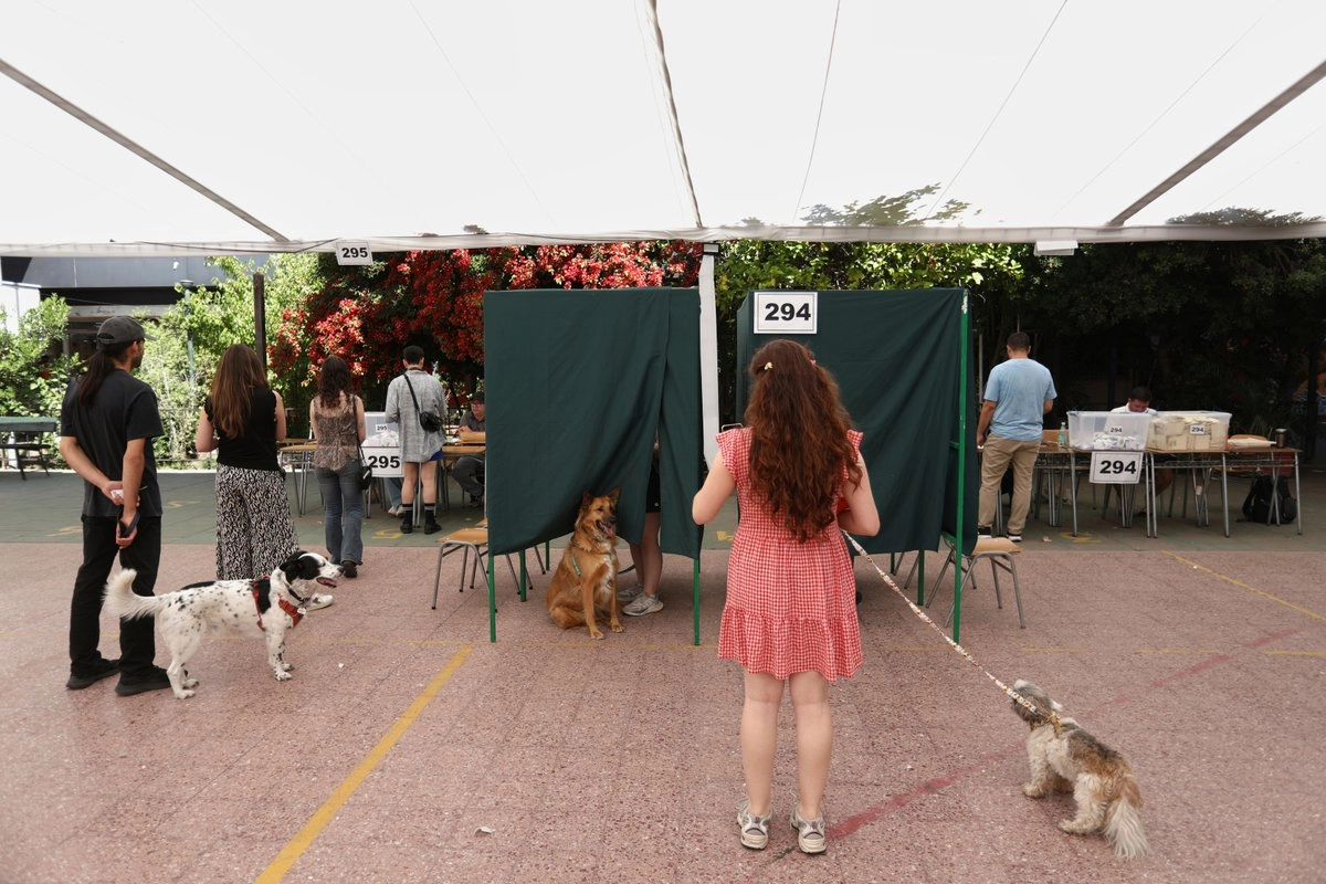 Electores y sus perros hacen fila en un centro de votación durante las elecciones generales en Santiago de Chile, el domingo 16 de noviembre de 2025.