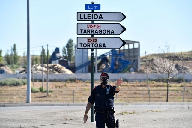 Un miembro de la policía catalana en un punto de revisión camino a Lérida, en España. Foto Afp

