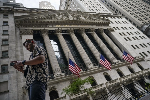 Persona camina a las afueras de la Bolsa de Nueva York. Foto Ap