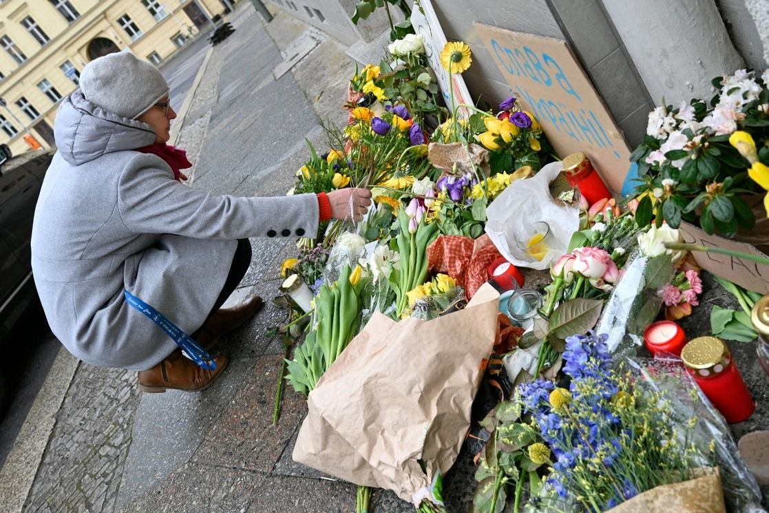 Una mujer deposita flores en un improvisado memorial por las víctimas ucranias del ataque ruso, frente a la embajada de Ucrania en Berlín, el 25 de febrero de 2022. Foto Afp