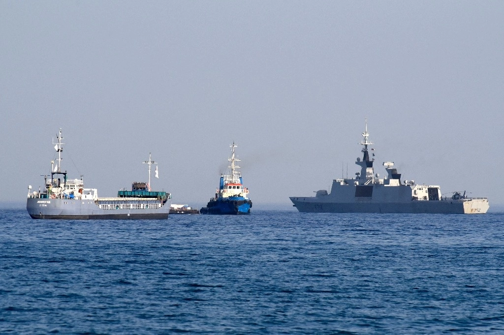 La barcaza Jenifer, parte de una flotilla de tres barcos que transporta ayuda alimentaria para la Franja de Gaza, navega junto a la fragata francesa Courbet cuando la flotilla sale del puerto de Larnaca en Chipre el 30 de marzo de 2024. Foto Afp