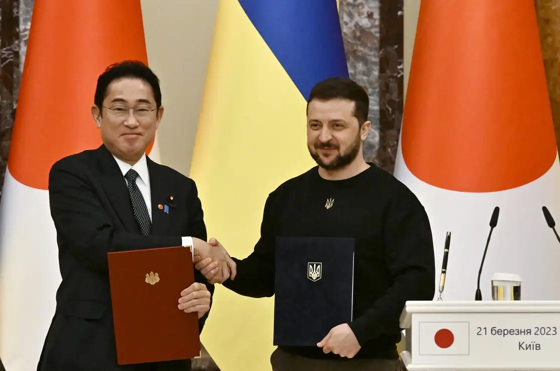 El presidente de Ucrania, Volodymir Zelensky (derecha), y el primer ministro de Japón, Fumio Kishida, se dan la mano tras la firma de documentos bilaterales antes de su conferencia de prensa conjunta tras su reunión en Kiev, el 21 de marzo de 2023. Foto Afp