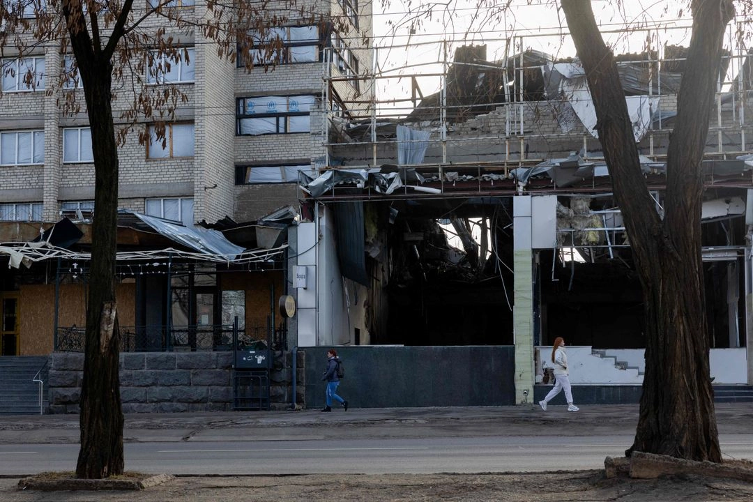 Personas caminan frente a edificio dañado en Kramatorsk, región de Donetsk, Ucrania, el 12 de marzo de 2025. Foto 