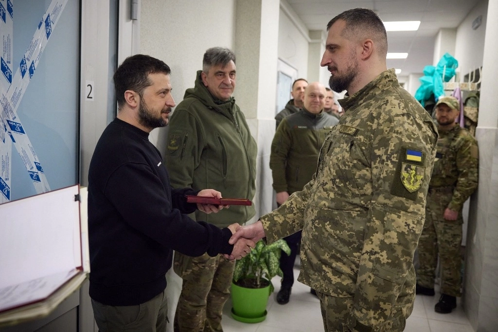 El presidente Volodimir Zelensky (izq.) otorga la Medalla de Honor a un militar mientras se encuentra con militares en un hospital, cerca de Bakhmut, Ucrania, el 22 de marzo de 2023. Foto Servicio de prensa presidencial de Ucrania / Afp