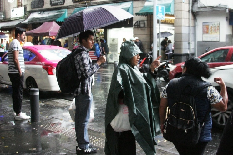 Personas se resguardan de las lluvias. Foto Roberto García Rivas