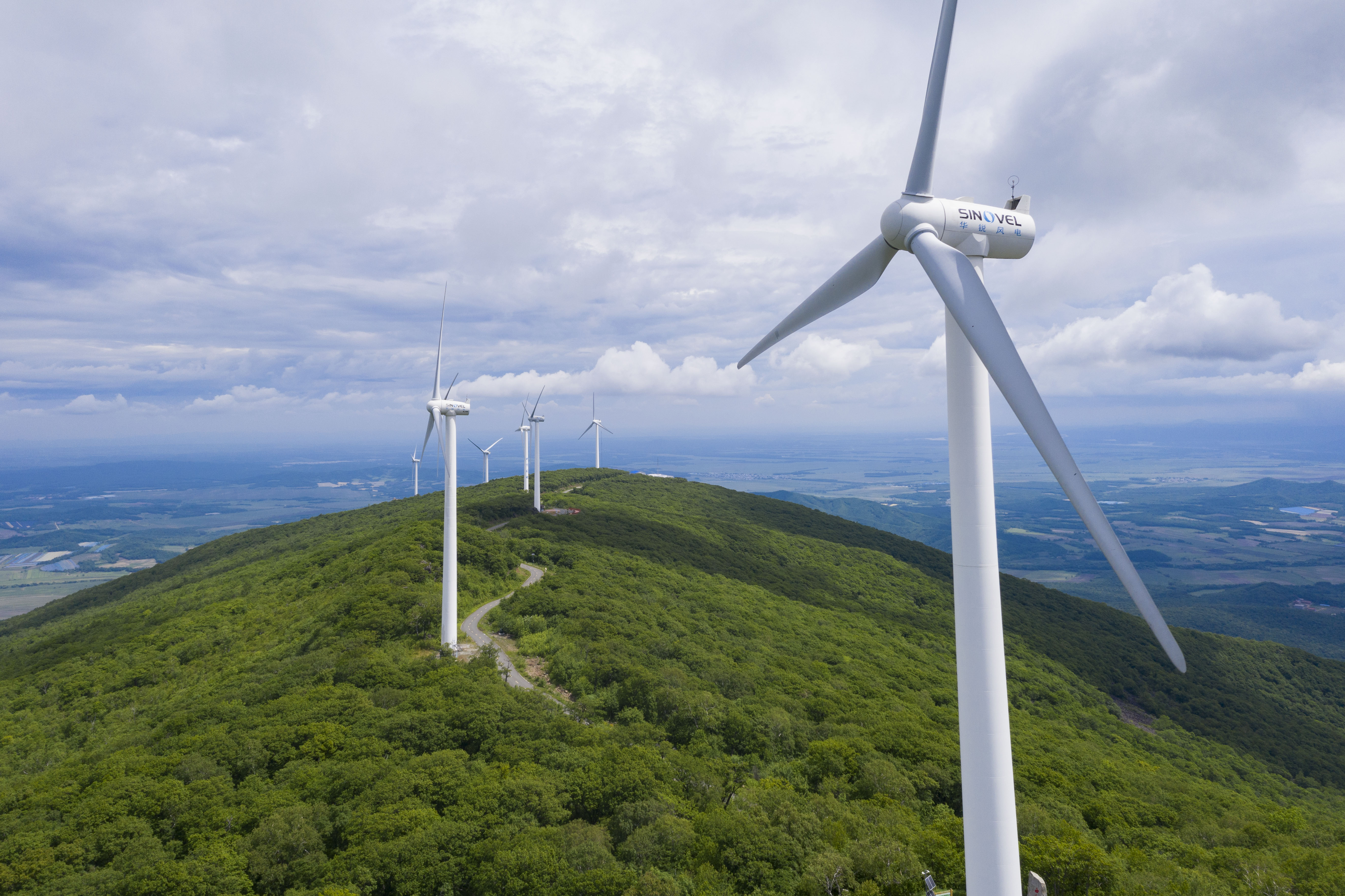 La foto aérea, tomada el 19 de junio de 2022, muestra las turbinas eólicas en un parque forestal en el distrito de Raohe, en la provincia nororiental china de Heilongjiang. (Xinhua/Xie Jianfei) Foto 